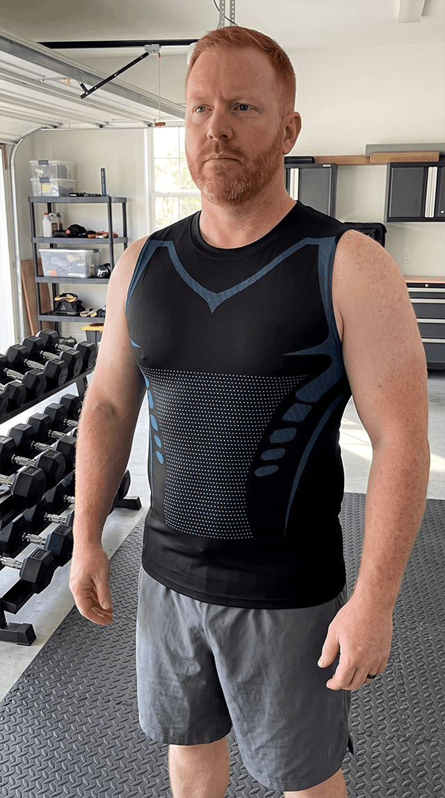A man in his garage gym wearing the black CoreLock tank